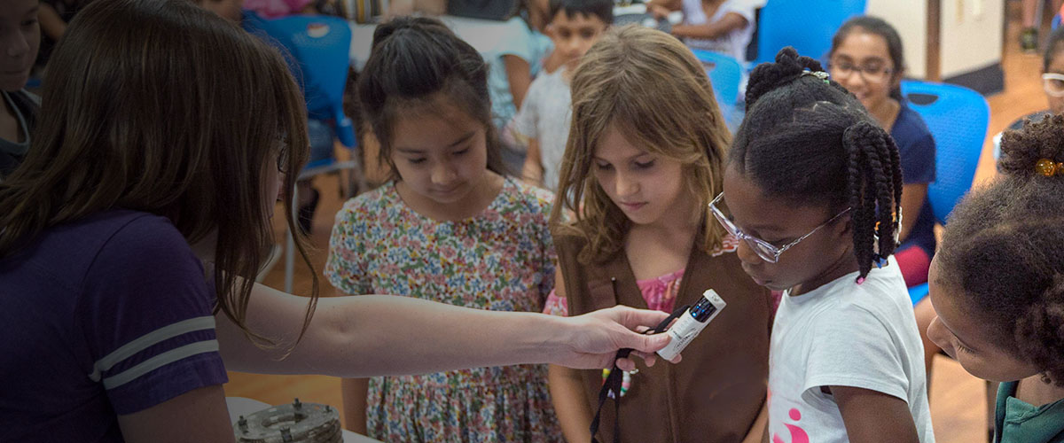 Scientist doing an experiment with children during Open House