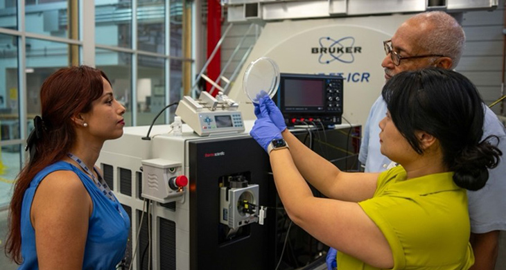 Dr. Huan Chen shows a bacteria sample to Dr. Grisel Fierros-Romero and Dr. Henry N. Williams.