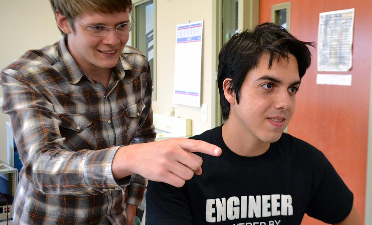 Jeremy Weiss, a young MagLab materials scientist and mentor, points to some of the data plotted by MagLab intern Gerardo Nazario.