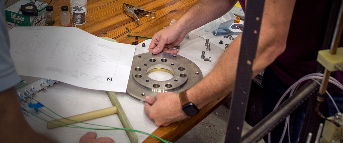 Engineer looking over fabricated parts and drawings